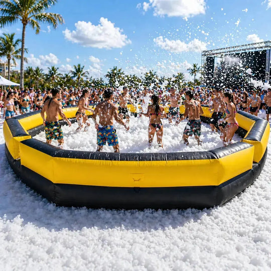 Group of people playing in a foam pit on a sunny day with palm trees in the background