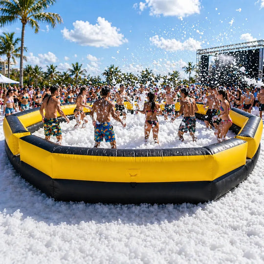 Group of people playing in a foam pit on a sunny day with palm trees in the background