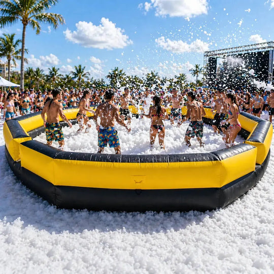 Group of people playing in a foam pit on a sunny day with palm trees in the background